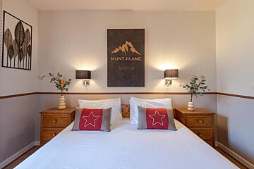 A bedroom with a sign above the bed that says mont blanc
