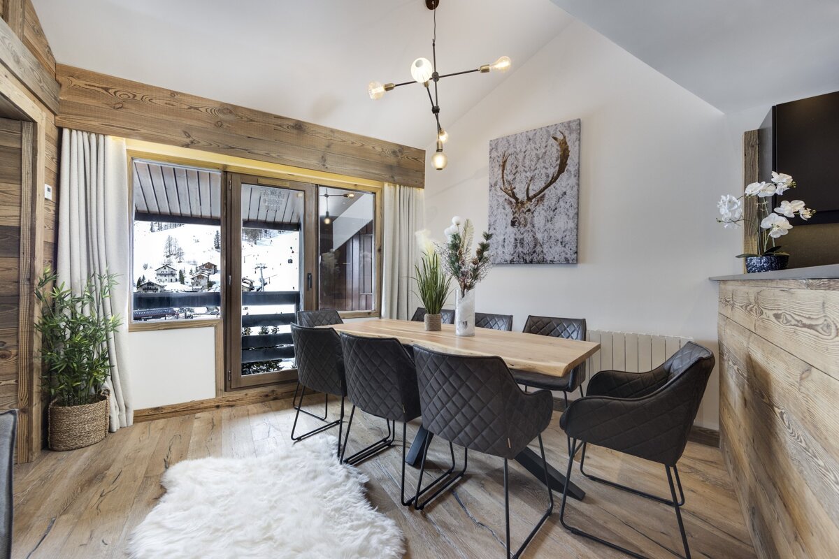 A dining room with a painting of a deer on the wall
