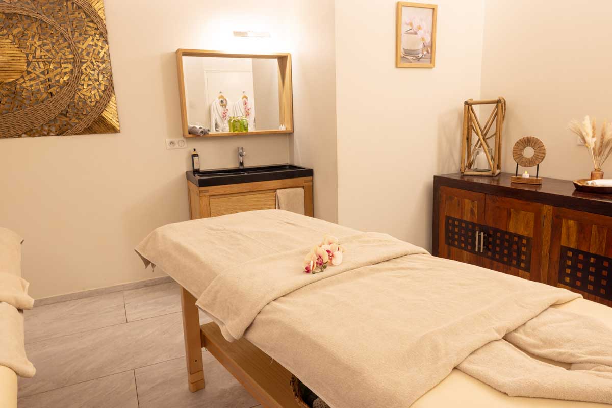 A massage table in a room with a sink and mirror
