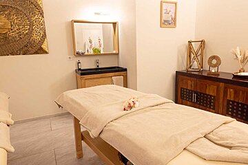 A massage table in a room with a sink and mirror