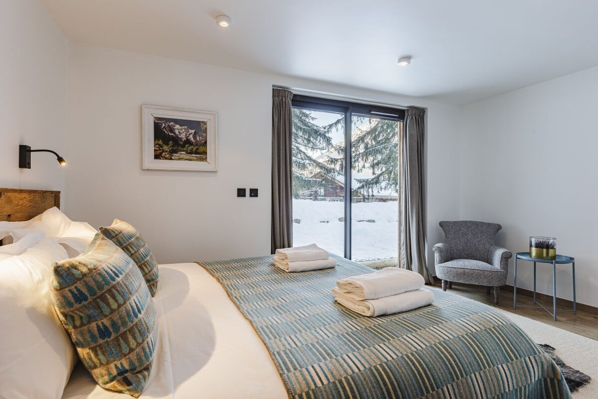 A bedroom with a king size bed and a chair