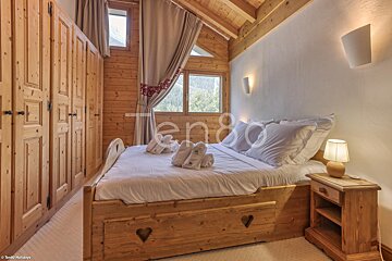 A bedroom with a bed and a nightstand and the word ten80 on the wall