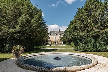 A large stone fountain in front of a castle