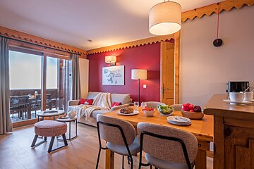A living room with a red wall and a picture on the wall that says