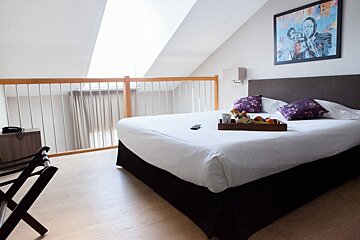 A hotel room with a tray of food on the bed