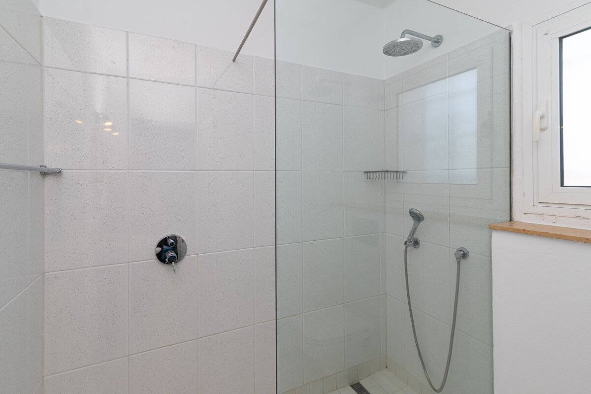 A shower with a glass door and a window