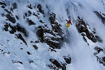 A person is skiing down a snow covered mountain