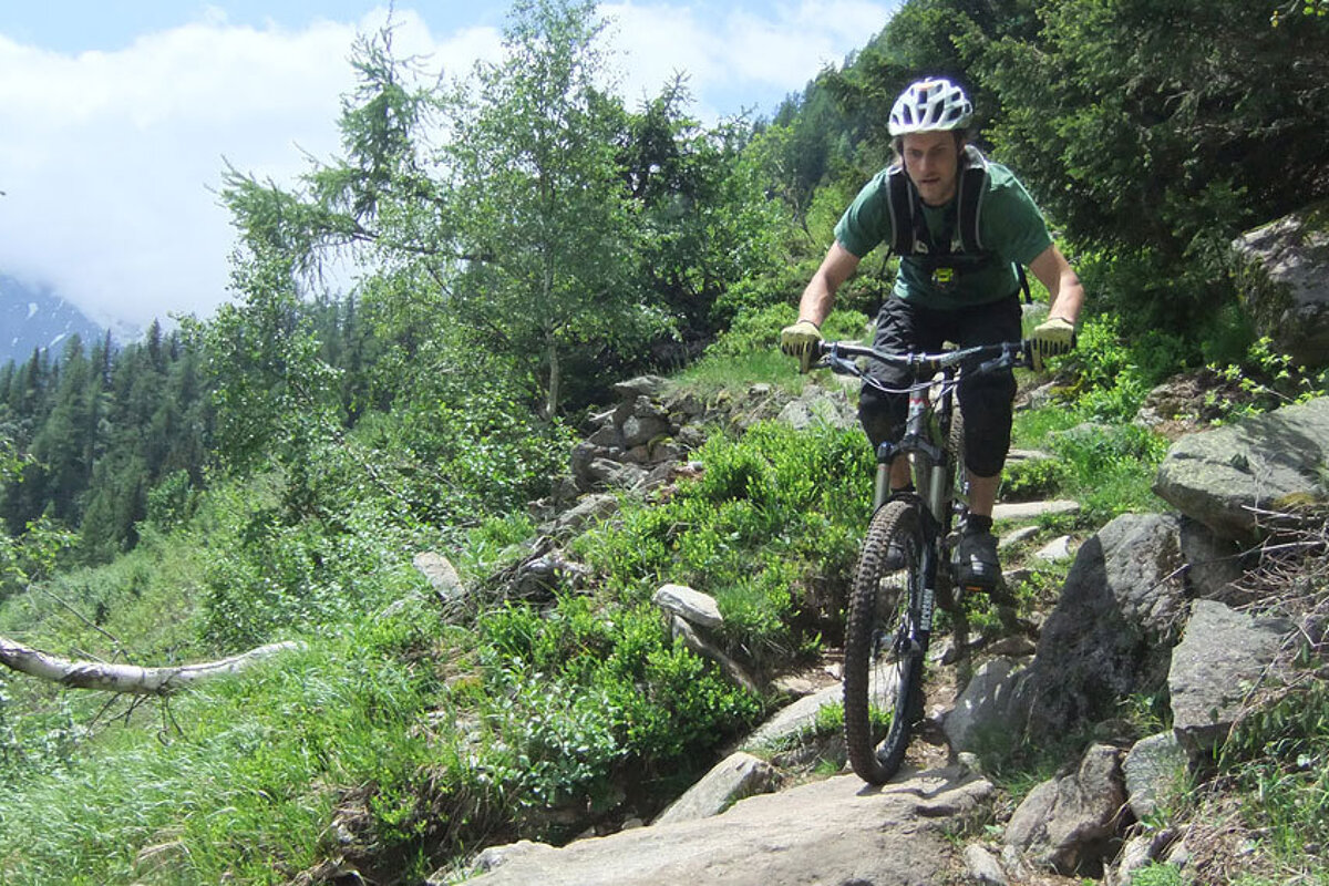 a mountain biker riding a technical trail in chamonix