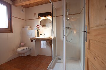 A bathroom with a toilet a sink and a shower