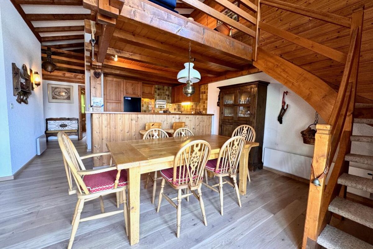A dining room with a table and chairs and stairs
