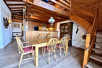 A dining room with a table and chairs and stairs