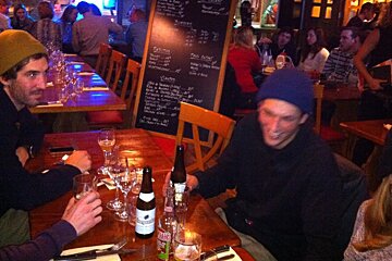 4 people at a table with a menu board behind them