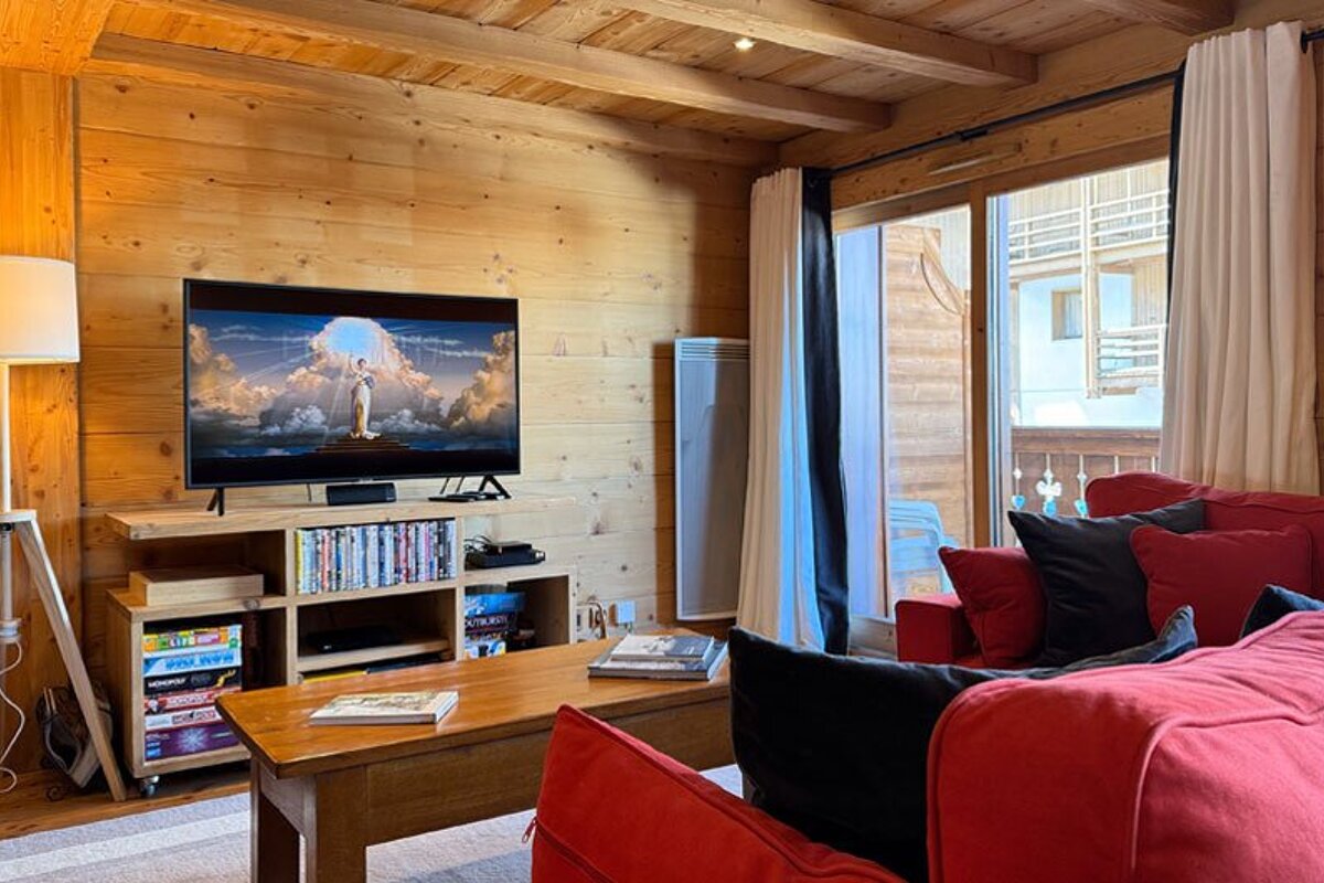 A living room with a red couch and a flat screen tv