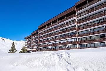 A large building with a lot of windows is covered in snow