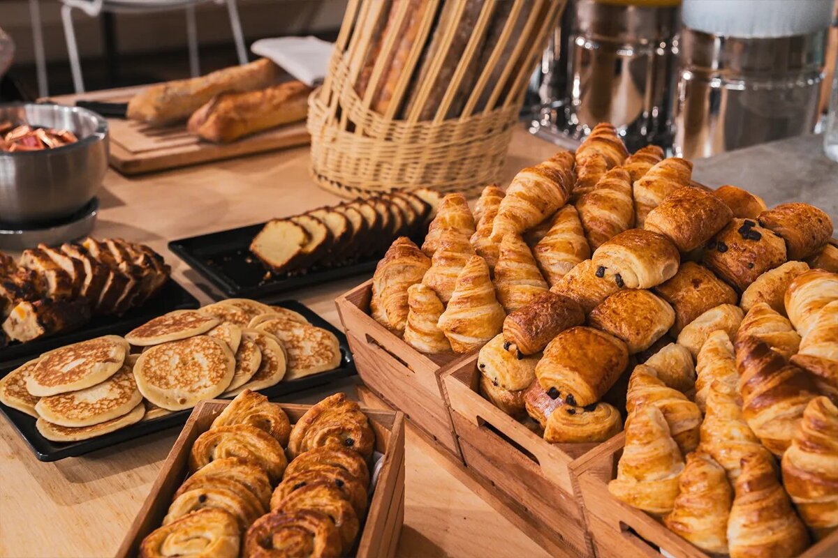 A variety of pastries on a table including croissants and pancakes