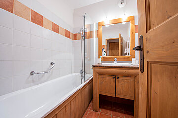 A bathroom with a bathtub a sink and a mirror