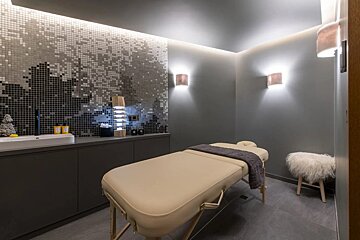 A massage table in a room with a mosaic wall
