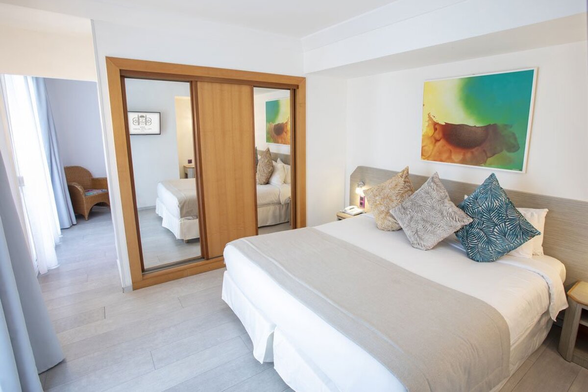 A hotel room with a bed and a painting on the wall