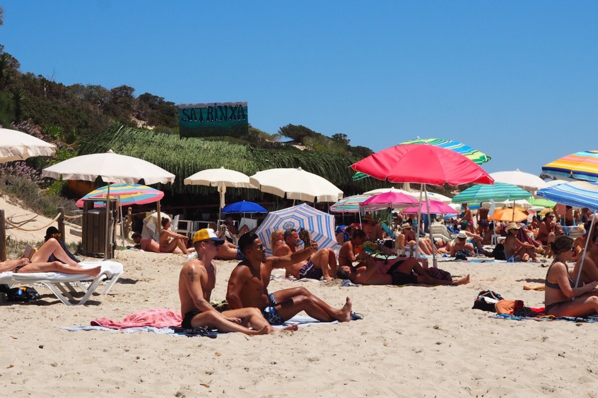 A beach club with parasols & sunbathers in Las salinas