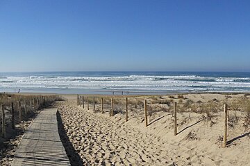 a wooden walkway to a beach adn ocean