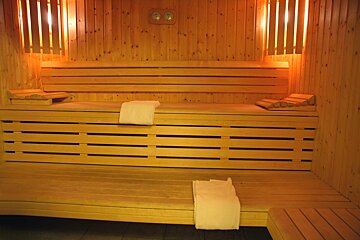 A wooden sauna with two clocks on the wall
