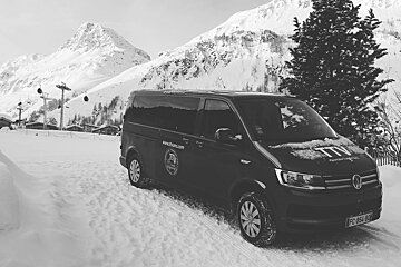 A black and white photo of a van in the snow