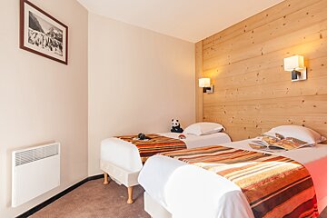 A bedroom with two beds and a picture on the wall