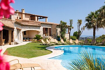 A large house with a swimming pool in front of it