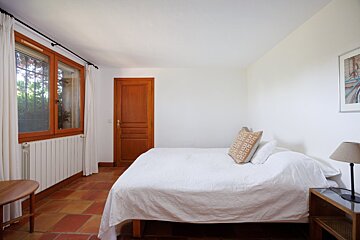 A bedroom with a bed and a picture on the wall