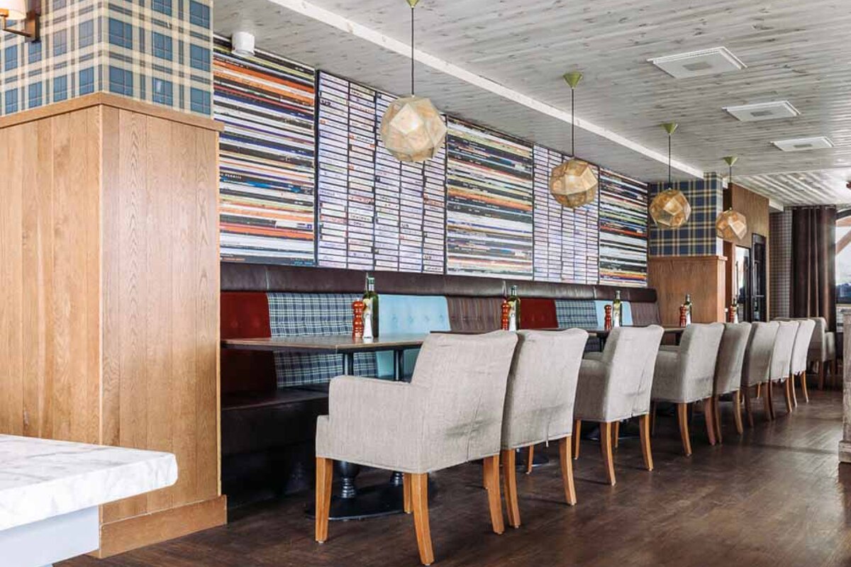 A long row of tables and chairs in a restaurant