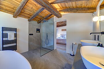 A bathroom with two sinks and a walk in shower