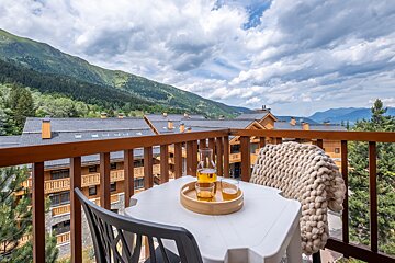 A balcony with a view of mountains and buildings