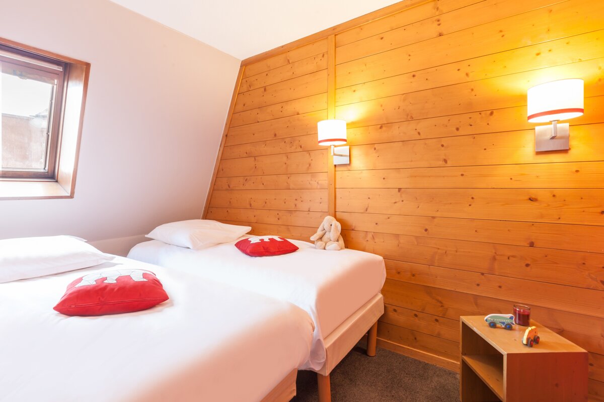 A bedroom with two twin beds and a window