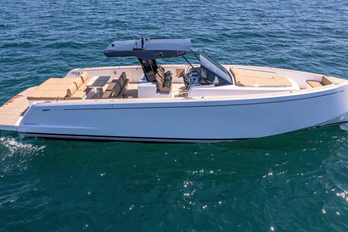 A white boat is floating on top of a body of water