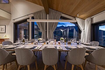 A dining room with a long table and chairs