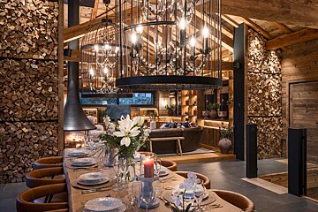 A dining room table with plates and candles on it