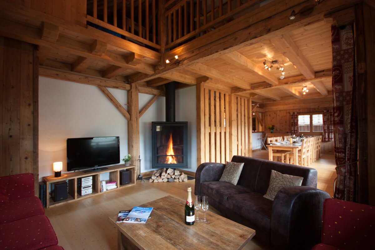 A bottle of champagne sits on a wooden table in a living room
