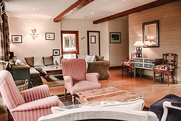 A living room with striped chairs and a wooden table