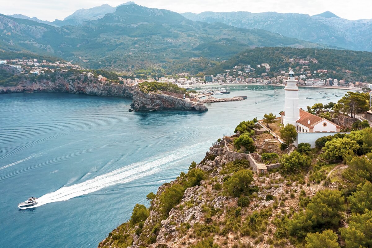 A lighthouse sits on a cliff overlooking a body of water