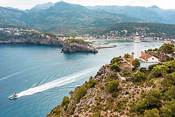 A lighthouse sits on a cliff overlooking a body of water