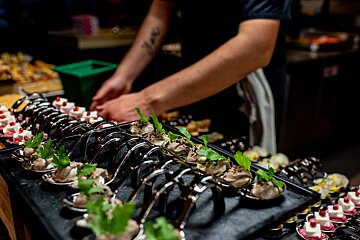 A man with a tattoo on his arm is preparing food