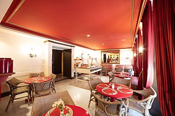A restaurant with red tables and chairs and a red ceiling