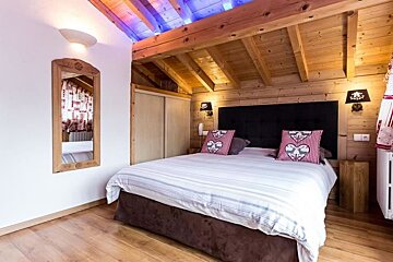 A bedroom with a king size bed and a mirror