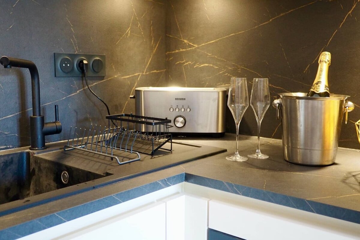 A kitchen counter with a toaster and a bucket of champagne