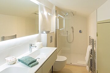 A bathroom with a toilet a sink and a shower