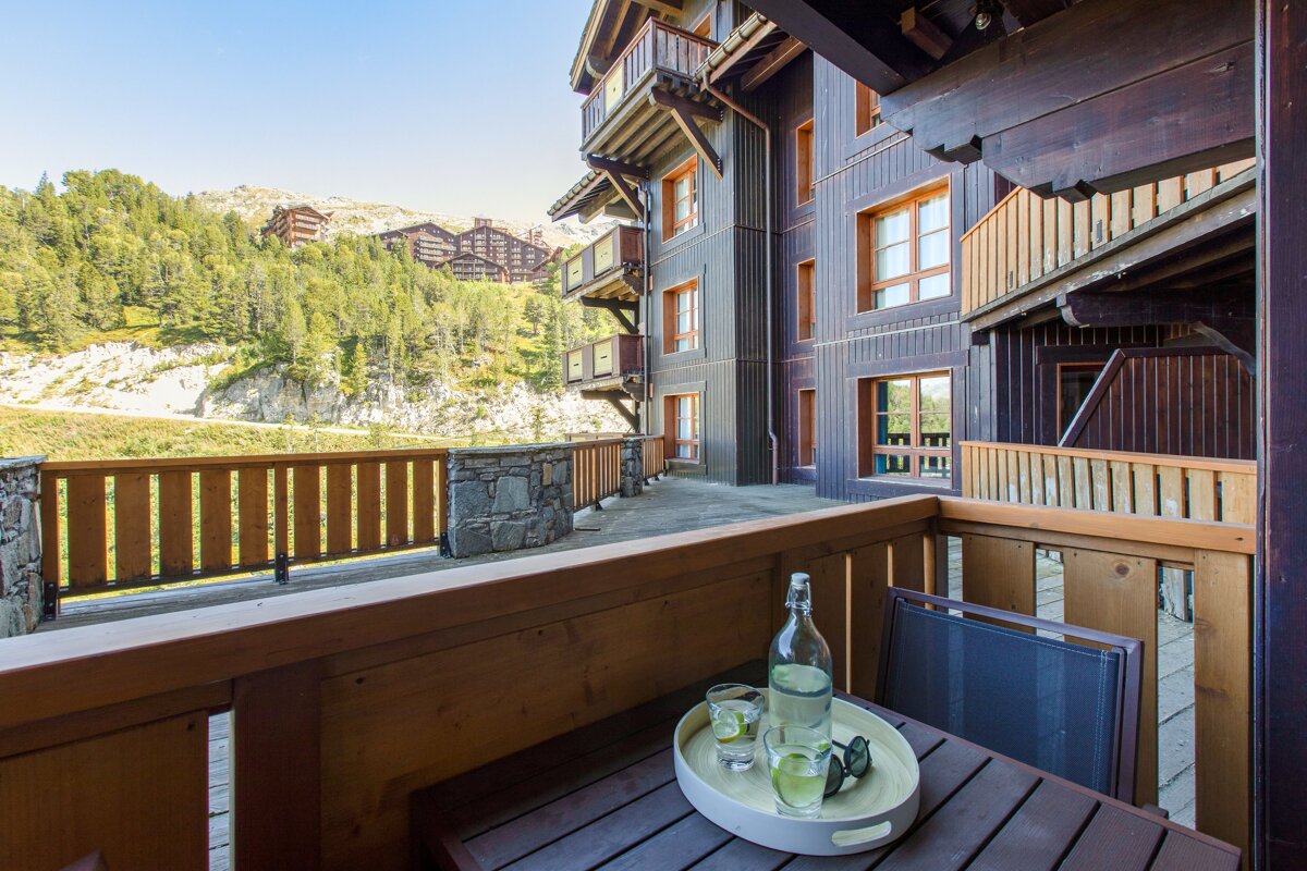 A balcony with a bottle of water and glasses on it