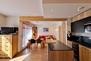 A kitchen with a table and chairs and a picture on the wall