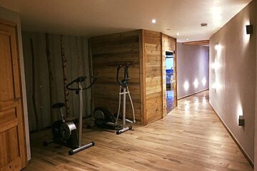 A hallway with a bicycle and an elliptical in it