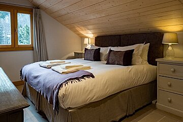 A bedroom with a large bed and two nightstands
