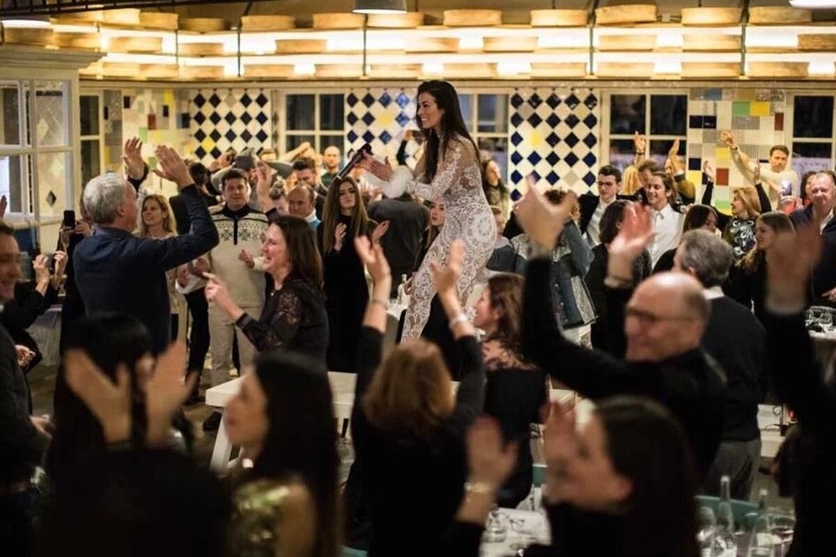 A woman in a white dress is dancing in front of a crowd